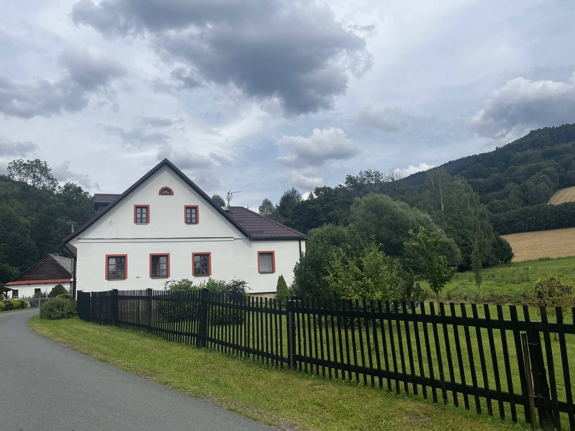 Biely dom za plotom v dedine pod horami
